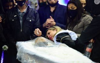 Viúva de MC Kevin chora abraçada sobre caixão e consola mãe do cantor em velório