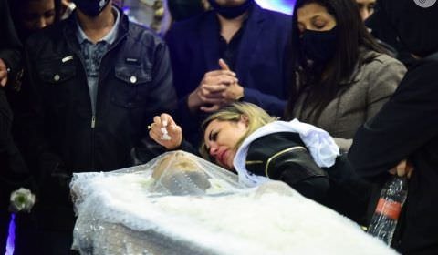 Viúva de MC Kevin chora abraçada sobre caixão e consola mãe do cantor em velório