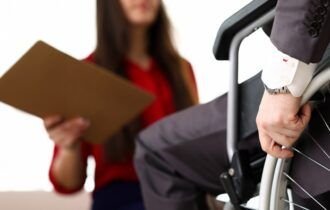 man-in-suit-on-wheelchair-communicates-with-woman