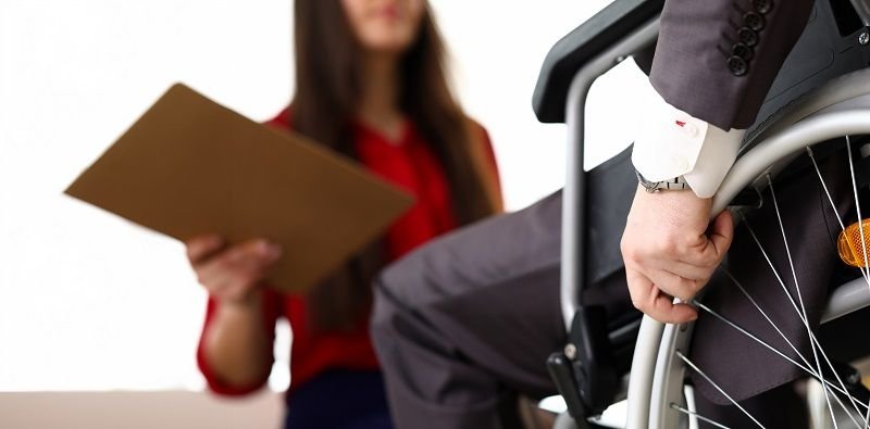 man-in-suit-on-wheelchair-communicates-with-woman