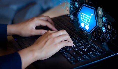 double-exposure-shopping-cart-businesswoman-using-laptop
